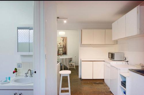 珀斯Gorgeous Subiaco cottage的白色的厨房配有水槽和微波炉