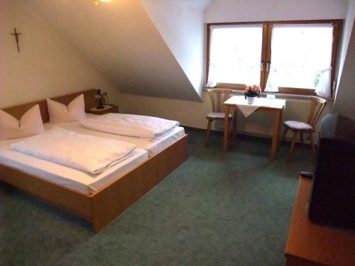 欧波楚巴赫埃尔泰珀斯特旅馆的一间卧室配有一张床、一张桌子和一个窗户。