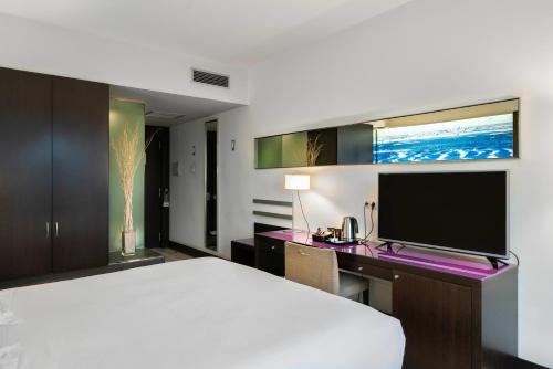 巴塞罗那马里迪莫温齐酒店的一间卧室配有一张床和一张书桌及电视