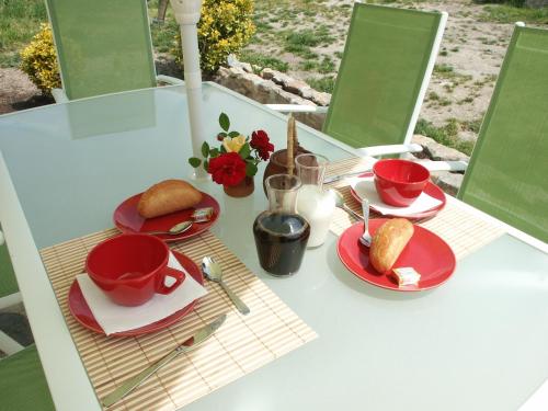 Saint-Dizier-les-Domaines螺旋客房的一张桌子,上面有红盘和杯子,上面有食物