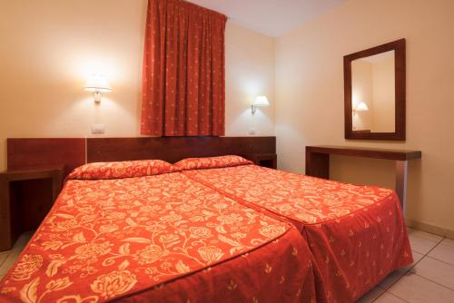 莫罗德哈布雷Blue Sea Jandia Luz的一间卧室配有一张带红色被子和镜子的床