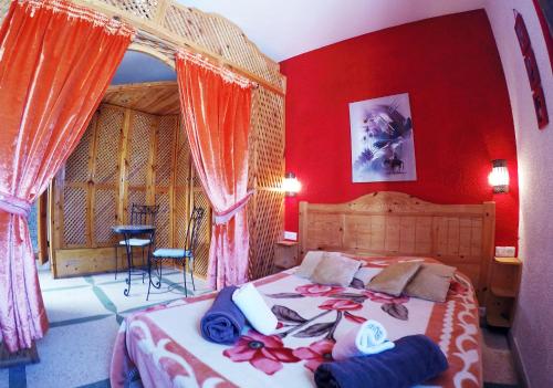阿加迪尔里亚德乐斯克缇斯达佳迪尔酒店的一间卧室设有一张带红色墙壁的大床