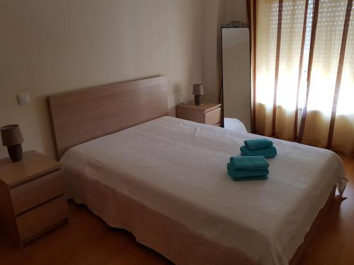 波尔蒂芒Encosta da Marina Residence的一间卧室配有一张床,上面有两条毛巾