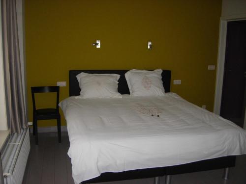 雷尼格尔斯特维达斯图斯旅馆的一间卧室配有一张白色的床和绿色的墙壁