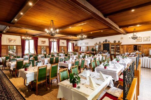 圣莫里茨宾龙酒店的用餐室配有白色的桌子和绿色的椅子