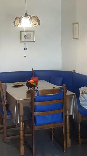 坎波马里诺appartamento Lory的一间带桌子和蓝色沙发的用餐室