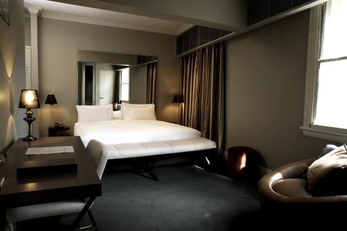 悉尼悉尼凯克登酒店的配有一张床和一张书桌的酒店客房