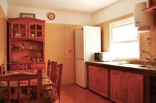圭马尔港Casita de playa的厨房配有白色冰箱和桌椅