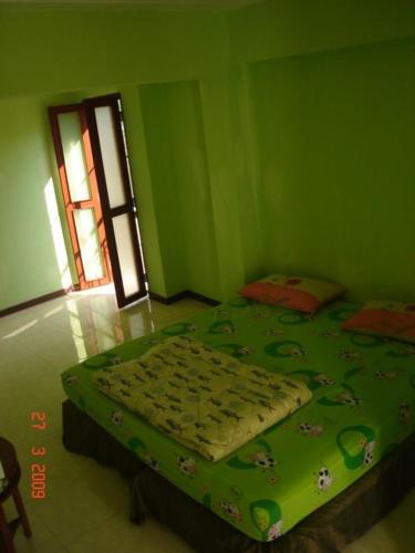 曼谷卡塞特旅馆的一间绿色卧室,卧室内配有一张床铺
