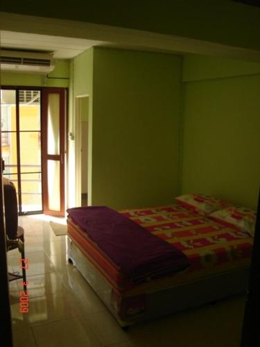 曼谷卡塞特旅馆的卧室设有一张位于绿色墙壁上的床铺