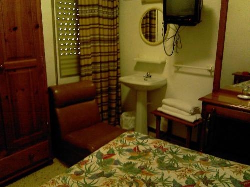 阿尔哈拉克伊格纳西奥旅馆的一间卧室配有一张床、一把椅子和一个水槽