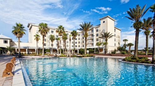 奥兰多奥兰多纪念酒店的棕榈树建筑前的大型游泳池