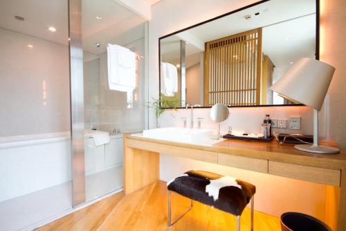 曼谷Maduzi Hotel, Bangkok - Asoke的一间带水槽和镜子的浴室