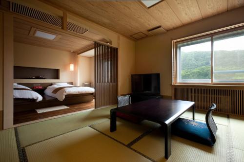 Jozankei章月格兰德酒店 的一间卧室配有一张床、一张桌子和一个窗户。