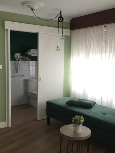 埃斯帕桑特港Las Palomas的一间卧室配有一张绿色的床和一张桌子