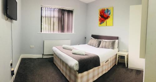 伦敦伦敦曼诺豪斯酒店的一间卧室配有一张床和一台电视