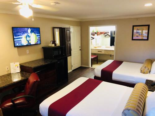 里弗赛德王朝套房酒店的酒店客房设有两张床和电视。