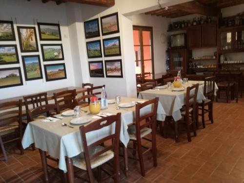 蒙泰斯佩尔托利博尔加斯特拉农家乐的用餐室配有桌椅,墙上挂有图片
