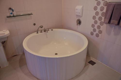 首尔钻石酒店的带白色浴缸的浴室和卫生间