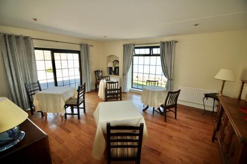 特拉利Barrow Lodge的客厅配有桌椅和窗户。