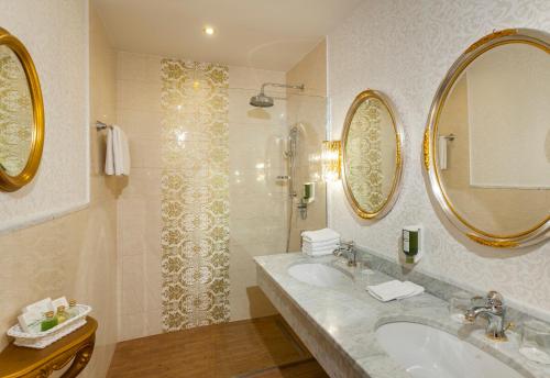格拉茨Parkhotel Graz - Traditional Luxury的浴室设有2个盥洗盆和带镜子的淋浴。