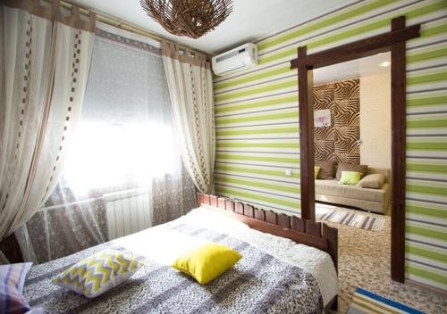 克拉斯诺亚尔斯克MVDC Siberia Apartments的一间卧室配有一张带黄色枕头和镜子的床