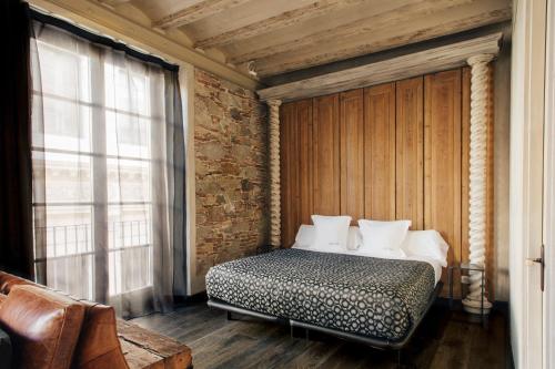 巴塞罗那阿莱4* 公寓式酒店的砖墙房间的一个床位