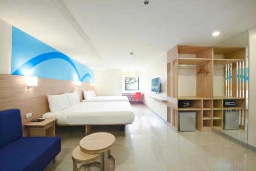 马尼拉Hop Inn Hotel Alabang Manila的酒店客房配有床、沙发和桌子。