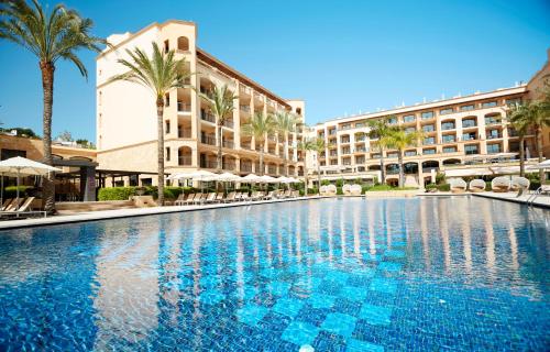 圣埃乌拉利亚因索特尔芬尼西亚名誉套房酒店和spa的棕榈树和建筑度假村内的游泳池