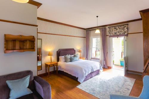 斯泰伦博斯恩德拉奇酒店的一间卧室配有一张床和两把椅子