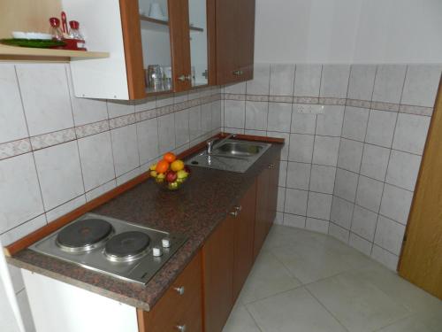马林斯卡Apartmani Lucija Jurković的厨房配有水槽和柜台上的一碗水果