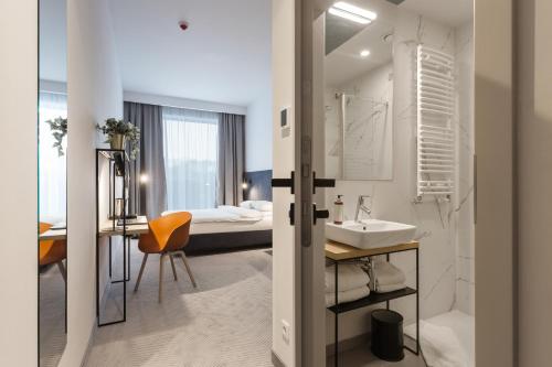 华沙维拉诺白金酒店的一间带水槽的浴室和一间带一张床的卧室
