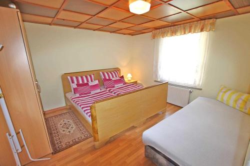 SilzFerienhaus Silz SEE 4581的一间卧室配有一张带粉色床单的床和一扇窗户。