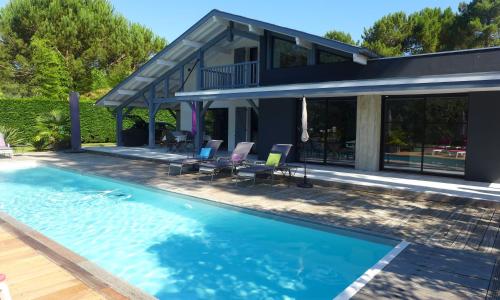 塞尼奥斯Ref 111 Seignosse, Villa de standing 4 étoiles partiellement climatisée avec piscine chauffée et Wifi au calme sur terrain 1100m2的房屋前的游泳池
