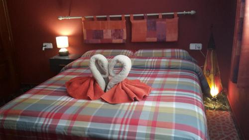 孔佩塔Casa del Sol的一张有两只天鹅的睡床,看起来像心脏