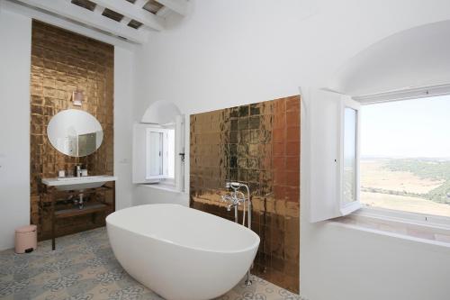 贝赫尔-德拉弗龙特拉Casa Bonhomía的一间带大型白色浴缸和窗户的浴室
