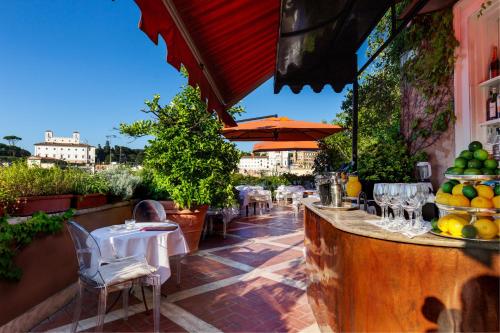 罗马广场大酒店的一个带桌椅和遮阳伞的庭院
