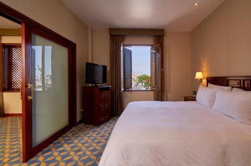 特鲁希略Costa del Sol Trujillo Centro的酒店客房设有一张大床和一台电视。