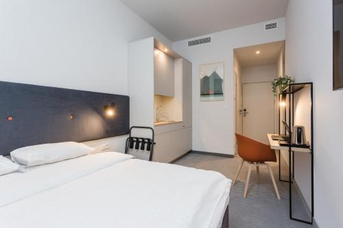 华沙维拉诺白金酒店的卧室配有白色的床和书桌