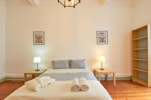 里斯本Palácio SantAnna的一间卧室配有带毛巾的床