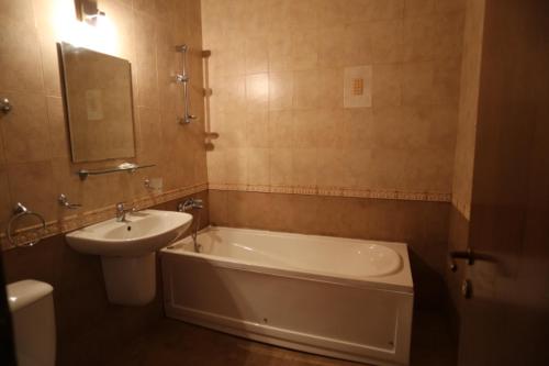 维丁海王星酒店的一间带水槽、浴缸和卫生间的浴室