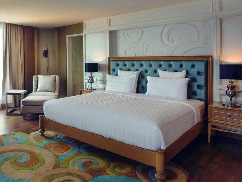 雅加达安佐尔会议中心美居酒店的一间卧室配有一张大床和一把椅子