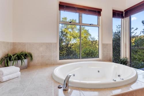 Ravensbourne雷文斯酷卡布拉度假屋的带窗户的浴室内的白色大浴缸