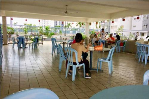 甲洞Suria Kipark Damansara 750sq ft Studio Apartment的一群坐在餐厅桌子上的人