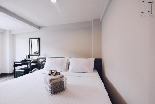 曼谷娜娜城市酒店的卧室配有一张白色的床,上面有篮子
