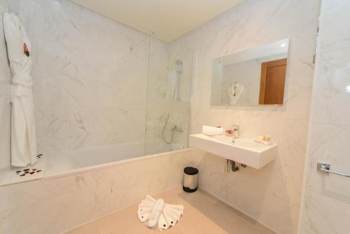 卡萨布兰卡Golden Star Casablanca的白色的浴室设有水槽、浴缸和水槽。