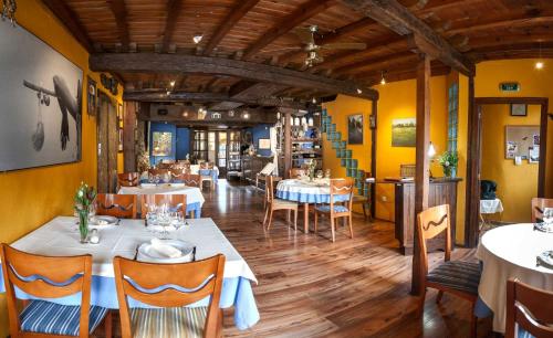 维拉弗兰卡·德尔·比尔Micro-Hostal La Puerta del Perdón的餐厅设有白色的桌椅和黄色的墙壁