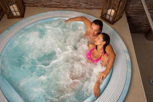 拉拉古纳拉古纳尼瓦利亚Spa大酒店的男人和女人在按摩浴缸里