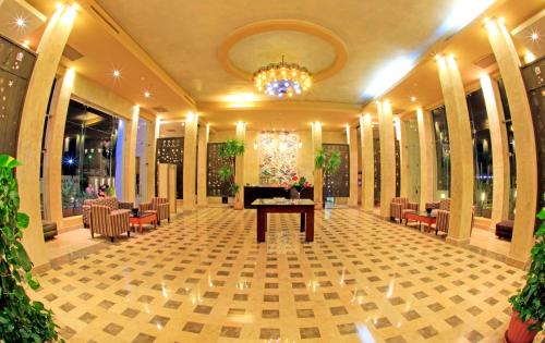 沙姆沙伊赫Sharm Club Beach Resort的大堂配有桌椅和吊灯。