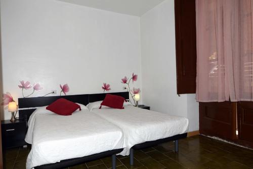 赫罗纳博拉斯酒店的一间卧室配有一张带红色枕头的床